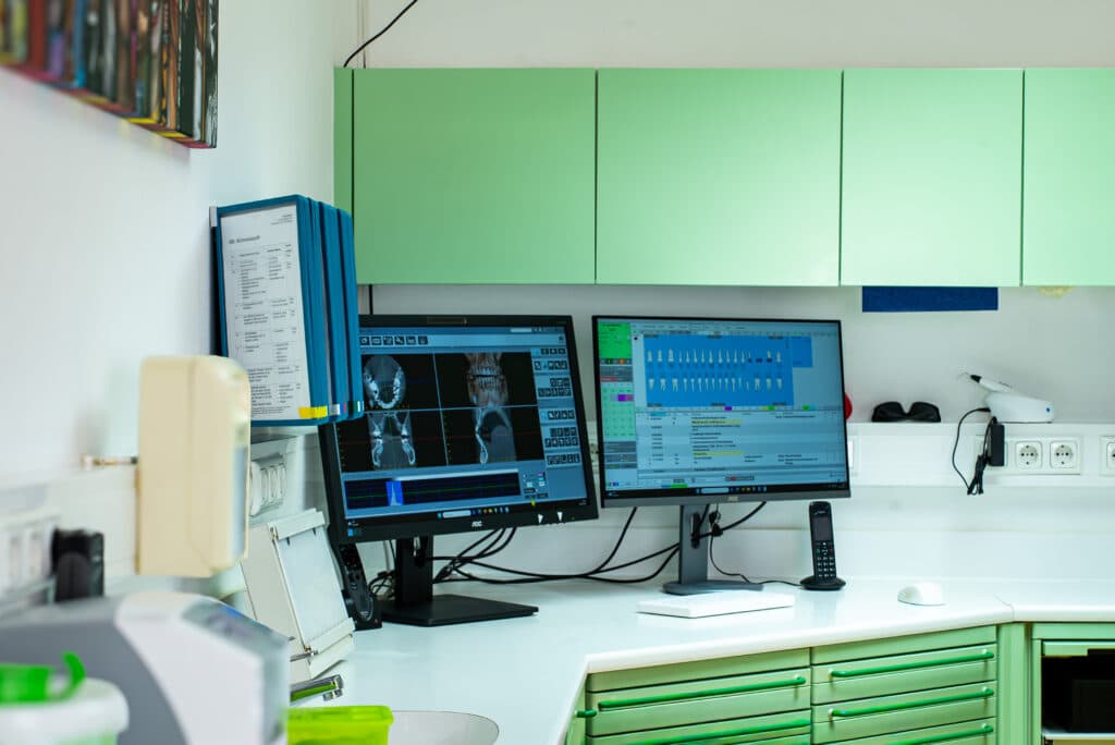 Digitale 3D-Implantatplanung an den Monitoren der Zahnarztpraxis Salzburg